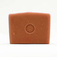 Brown pink bar of soap, emobssed with TONIC's floral logo design, on a white background