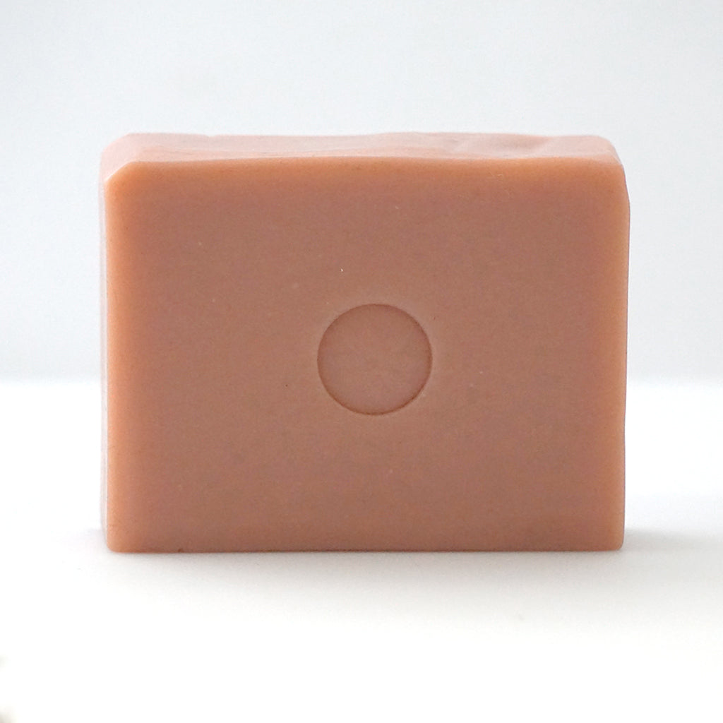Front view of TONIC grapefruit pink bar soap on an off-white background