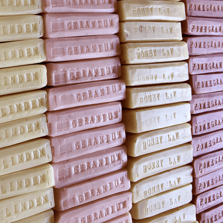 Stack of floral mini bar soaps Linden, Geranium, Honey Lavender, and Pomegranate