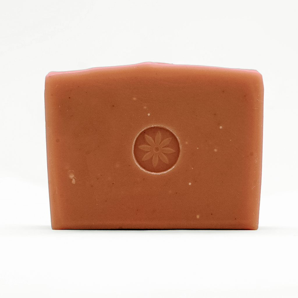 Brown pink bar of soap, emobssed with TONIC's floral logo design, on a white background