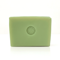 A bright green Neroli soap bar unwrapped on a white background