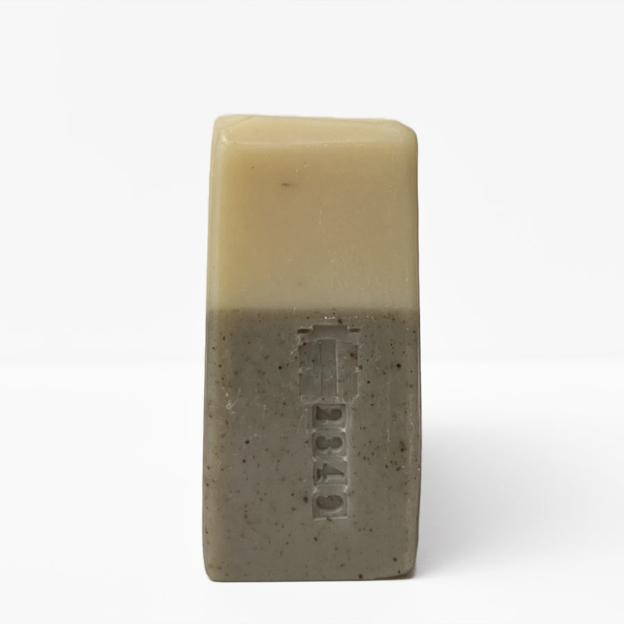The unwrapped side view of eucalyptus bar soap with a batch stamp, by TONIC