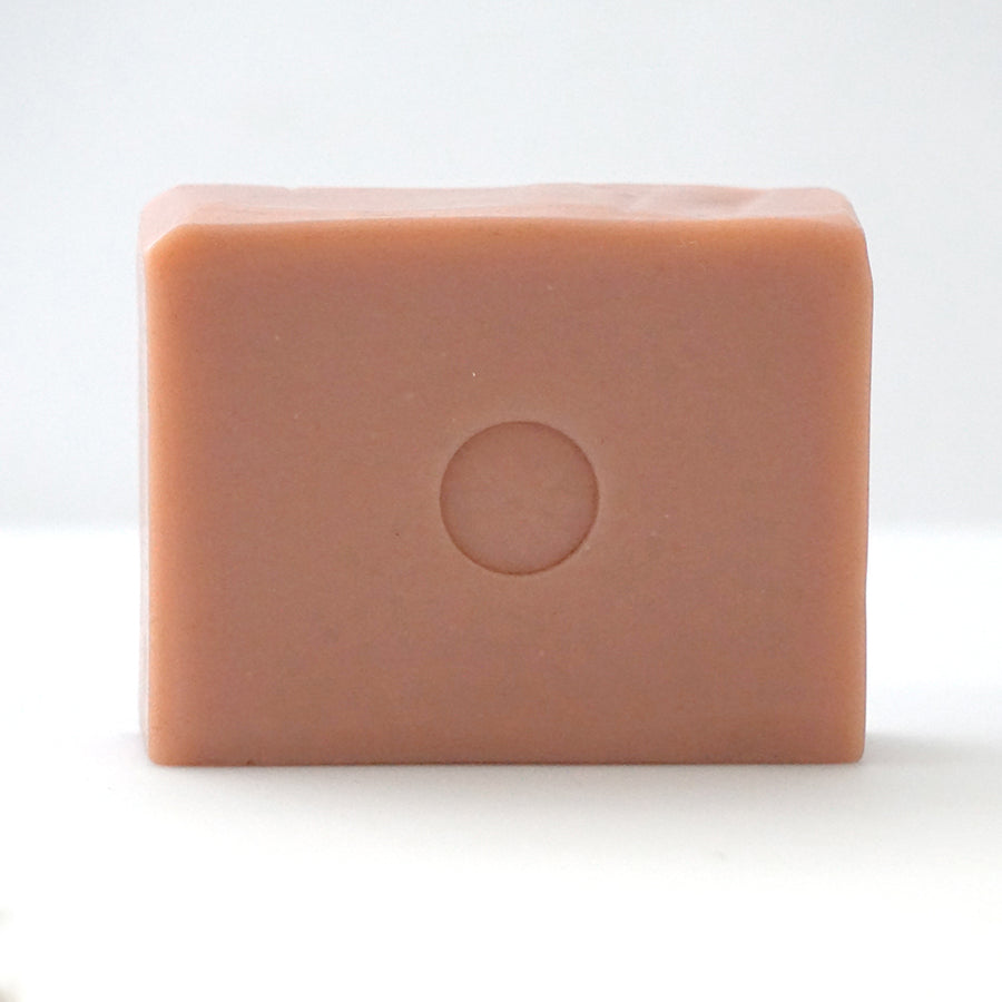 Front view of TONIC grapefruit pink bar soap on an off-white background