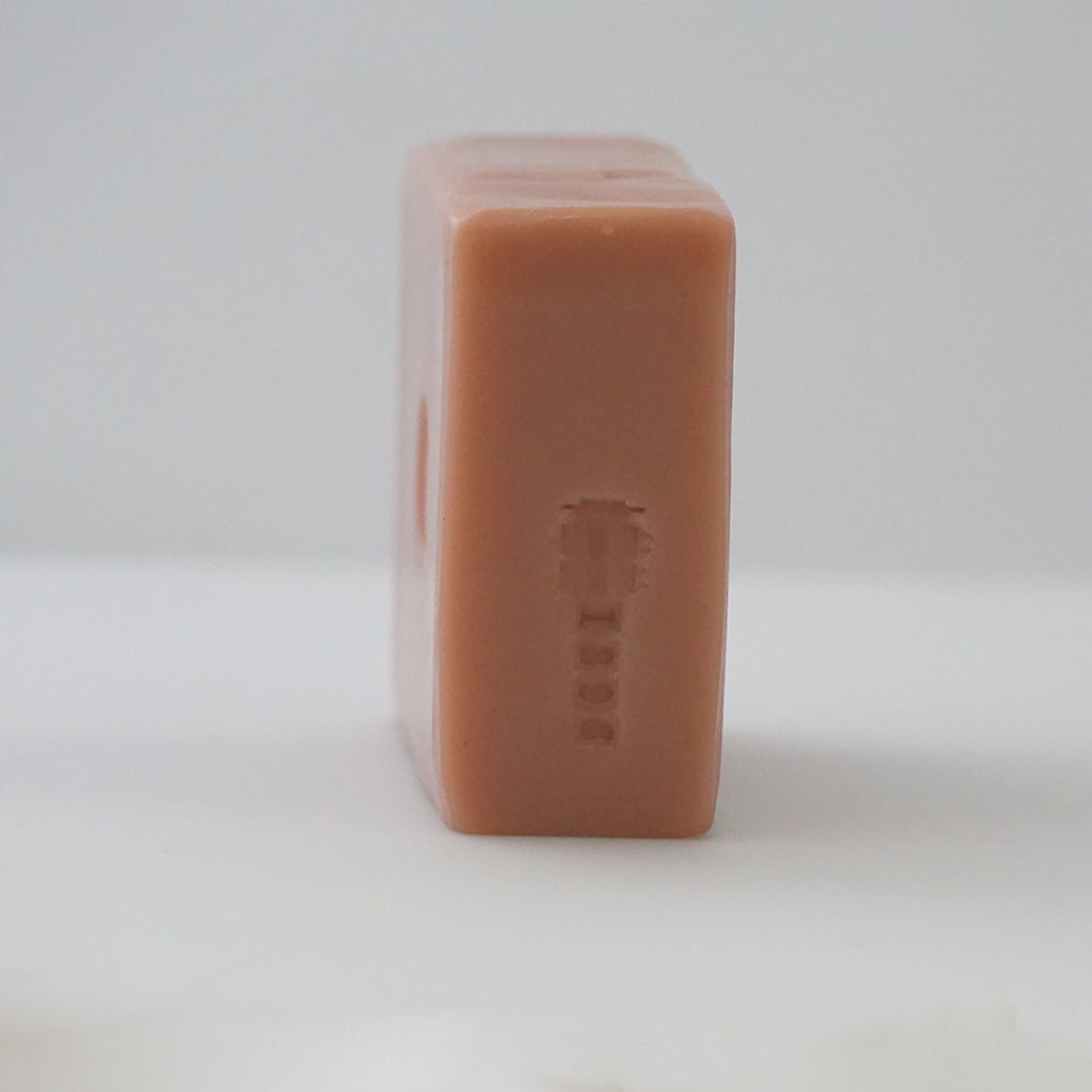 Side view of an unwrapped TONIC Grapefruit Bar Soap displaying the batch number stamp