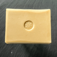 TONIC Meyer Lemon Handcrafted Bar Soap with Coconut Milk and Argan Oil by Tonic Naturals, unwrapped on a slate background.