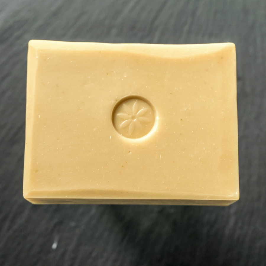 TONIC Meyer Lemon Handcrafted Bar Soap with Coconut Milk and Argan Oil by Tonic Naturals, unwrapped on a slate background.