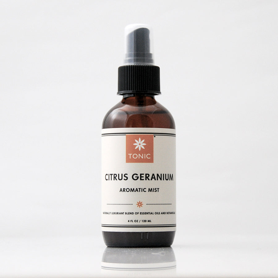 TONIC Citrus Geranium Aromatic Mist Room Spray in an amber glass bottle against a light grey background