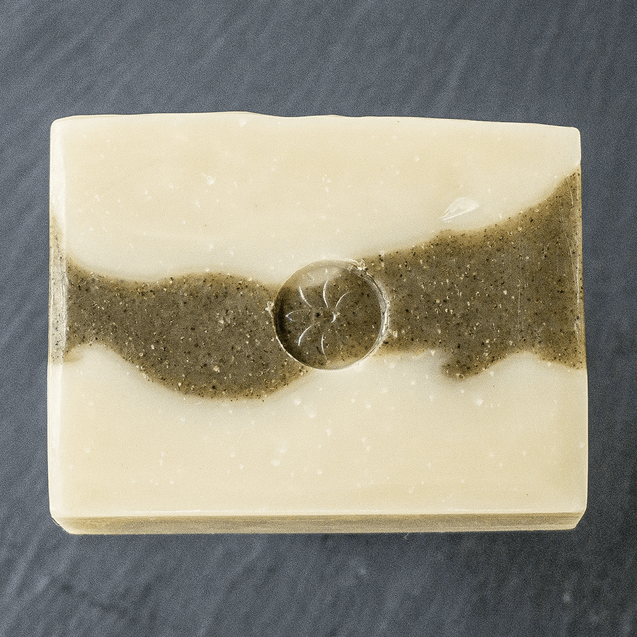 an unwrapped bar of Tonic Naturals Spruce and Fir soap on a black slate background
